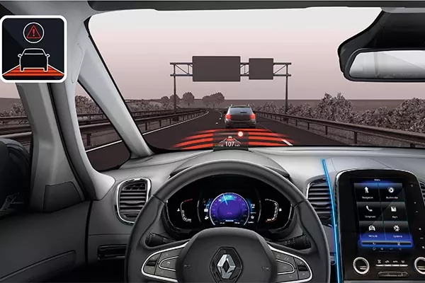Blick aus dem Inneren eines Fahrzeugs, der das Armaturenbrett und das Lenkrad zeigt, mit einer digitalen Anzeige, die den adaptiven Tempomat hervorhebt, während das Fahrzeug auf einer Autobahn einem anderen Auto folgt. In der linken oberen Ecke wird ein Warnsymbol angezeigt.