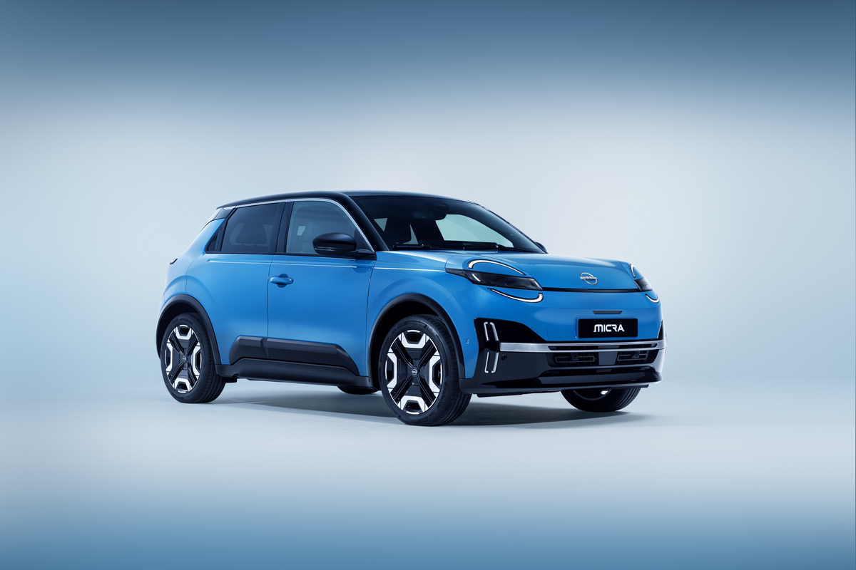 Ein hellblauer Nissan Micra, ein kompakter Geländewagen, wird in einer Studioumgebung mit einem blauen Hintergrund mit Farbverlauf gezeigt, von vorne links gesehen.