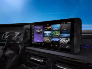 Ein modernes Armaturenbrett zeigt verschiedene Fahrmodi an, darunter Komfort, Eco und Sport, mit Bedienelementen für Sitze, Luftqualität und Klimaeinstellungen. Der Hintergrund ist ein klarer blauer Himmel.