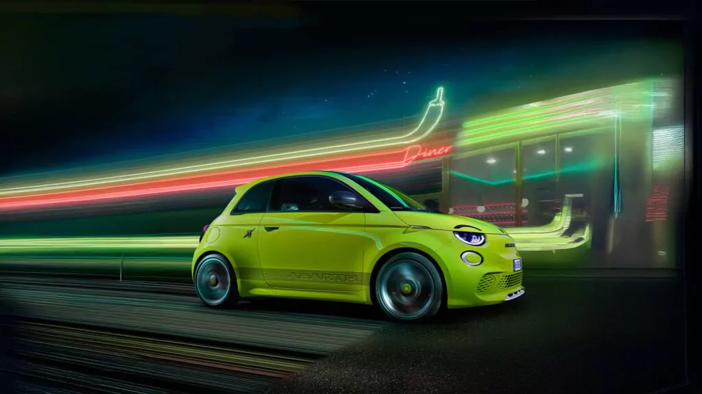 Ein leuchtend grüner, elektrischer Abarth 500e fährt nachts an einem neonbeleuchteten Lokal vorbei. Seine leuchtenden Lichtspuren und Reflexionen schaffen eine dynamische Szene - die perfekte Inspiration für Ihr nächstes Leasing-Abenteuer.