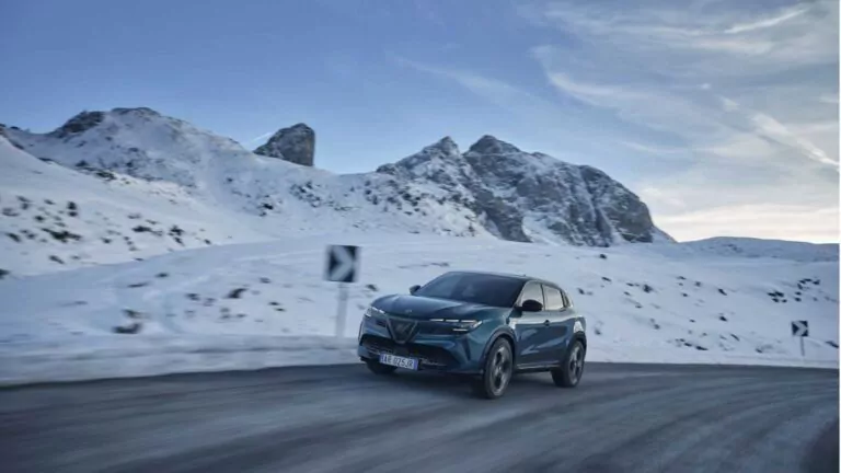 Alfa Romeo auf der Straße, im Hintergrund ein verschneiter Berg