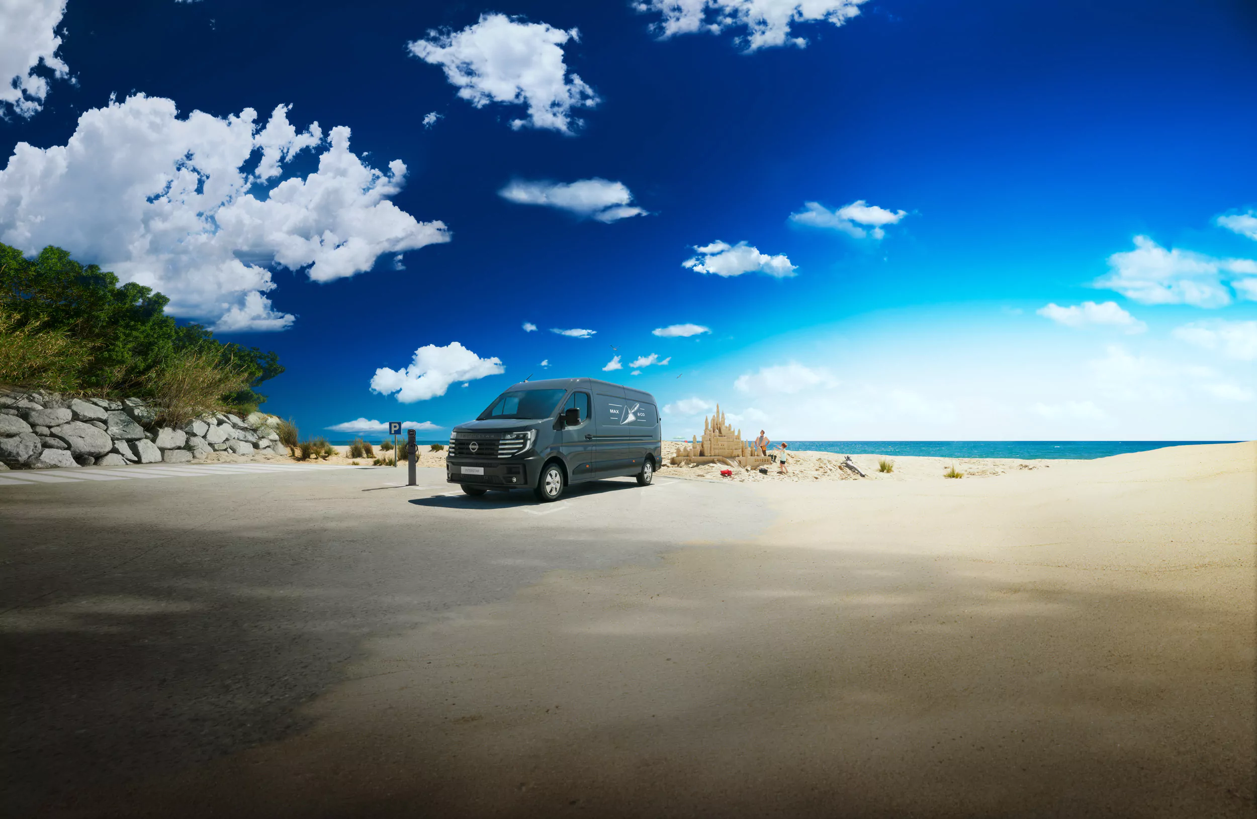 Ein schwarzer Nissan Interstar ist auf einer gepflasterten Fläche neben einem Sandstrand unter einem strahlend blauen Himmel mit vereinzelten weißen Wolken geparkt. Eine Sandburg und eine Person sind in der Ferne in der Nähe des Wassers zu sehen. Jetzt günstig leasen!.