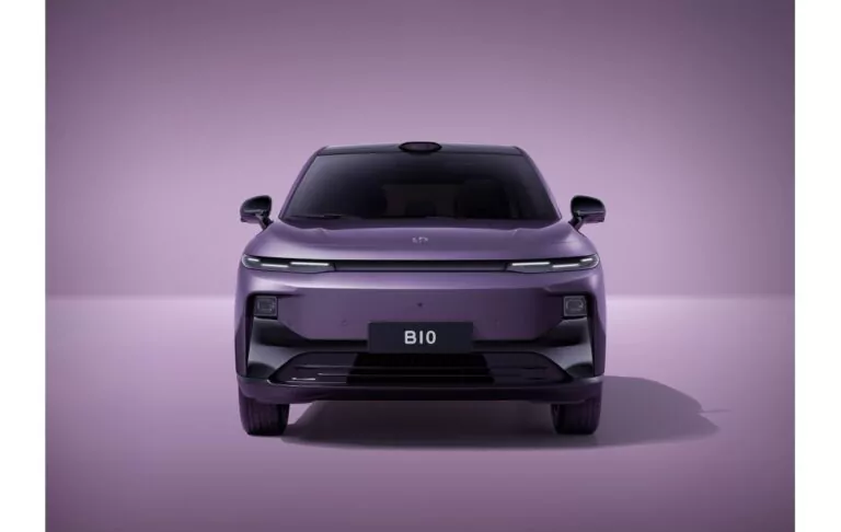 Frontansicht eines eleganten, modernen, violetten Elektroautos mit minimalistischem Design, schmalen Scheinwerfern und einem Nummernschild mit der Aufschrift B10 vor einem passenden violetten Hintergrund.