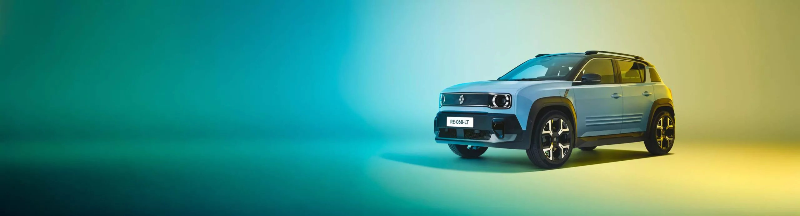 Ein blauer kompakter Geländewagen mit schwarzen Akzenten parkt auf einer glatten Fläche vor einem Hintergrund mit Farbverlauf, der sich in Grün und Gelb unterscheidet. Der Wagen ist nach rechts ausgerichtet, und auf dem vorderen Nummernschild ist e:Ny1 zu sehen.