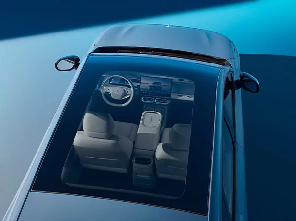 Draufsicht auf das Panoramadach eines Leapmotor B10, das einen modernen, hellen Innenraum mit zwei Vordersitzen, einem digitalen Armaturenbrett und einer Mittelkonsole zeigt. Das Auto ist auf einer blauen Fläche geparkt.