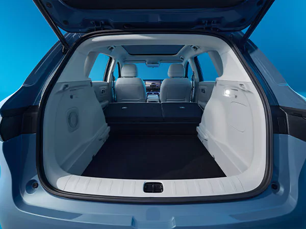 Ansicht des geräumigen hinteren Laderaums eines Leapmotor B10 mit geöffneter Heckklappe, umgeklappten Rücksitzen und hellem Innenraum, der bei heller Beleuchtung vor blauem Hintergrund reichlich Stauraum bietet.