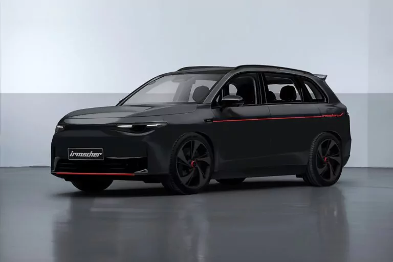 Ein schnittiger schwarzer Geländewagen mit getönten Scheiben, roten Akzenten und sportlichen schwarzen Rädern ist in einem sauberen, minimalistischen Innenraum geparkt. Auf dem vorderen Nummernschild steht Irmscher.