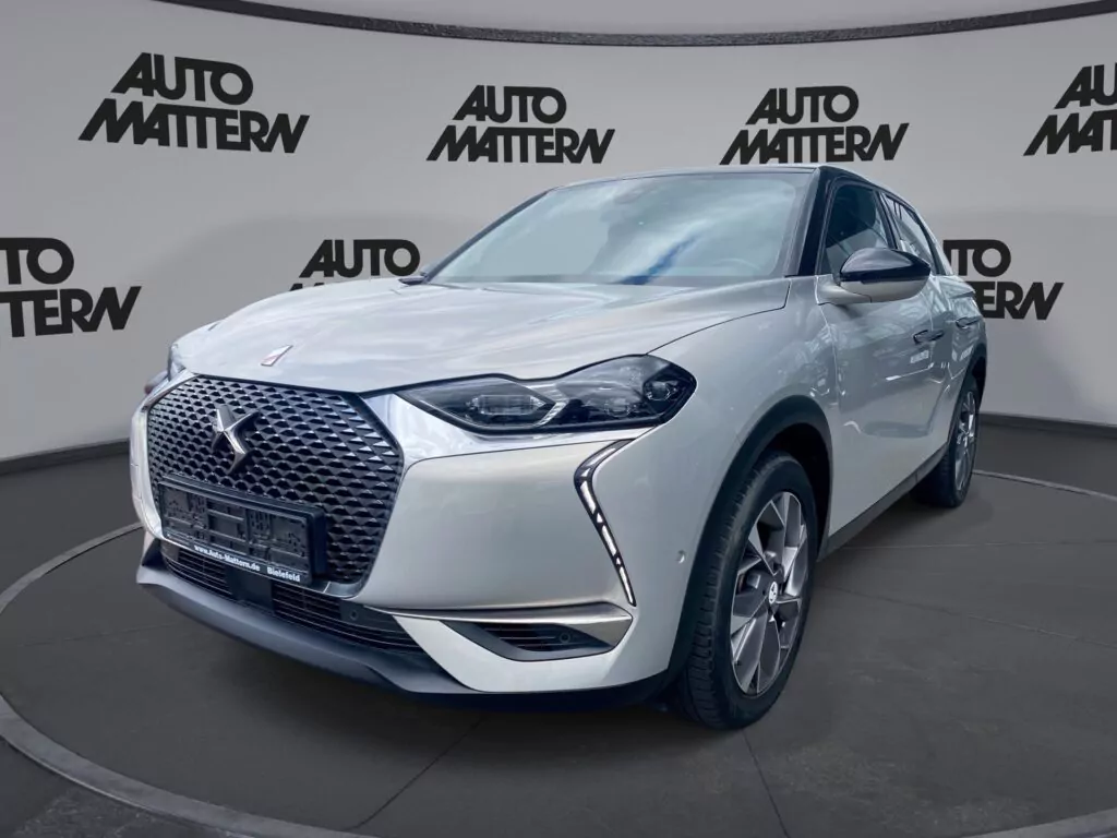 Ein weißer DS 3 Crossback SUV steht in einem Ausstellungsraum mit AUTO MATTERN-Branding an den Wänden, von vorne links gesehen - eine einladende Szene für den Tag der offenen Tür März 2026.