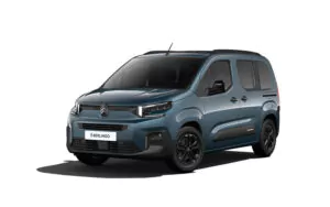Ein blauer Citroën ë-Berlingo Elektro-Van von vorne links gesehen, vor einem weißen Hintergrund. Der Van hat schwarze Leichtmetallräder, eine Dachreling und ein modernes Design mit LED-Scheinwerfern.