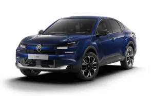 Ein blaues Citroën ë-C4 X-Elektroauto, das von vorne links auf weißem Hintergrund gezeigt wird und dessen schlanke Scheinwerfer, modernen Kühlergrill und sportliches, aerodynamisches Design hervorhebt.