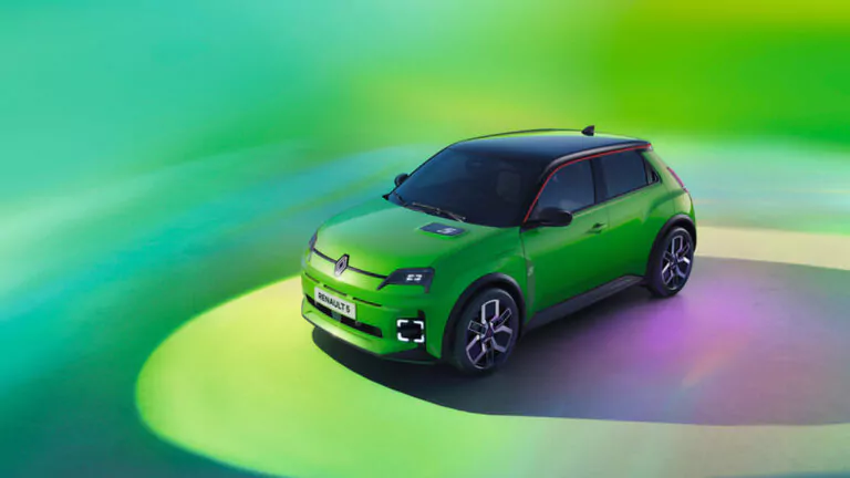 Ein leuchtend grünes Renault Schrägheck-Elektroauto ist auf einer Fläche mit bunten grünen und gelben Lichteffekten im Hintergrund geparkt. Das Auto ist modern, mit schwarzem Dach und Akzenten sowie beleuchteten Radkappen.