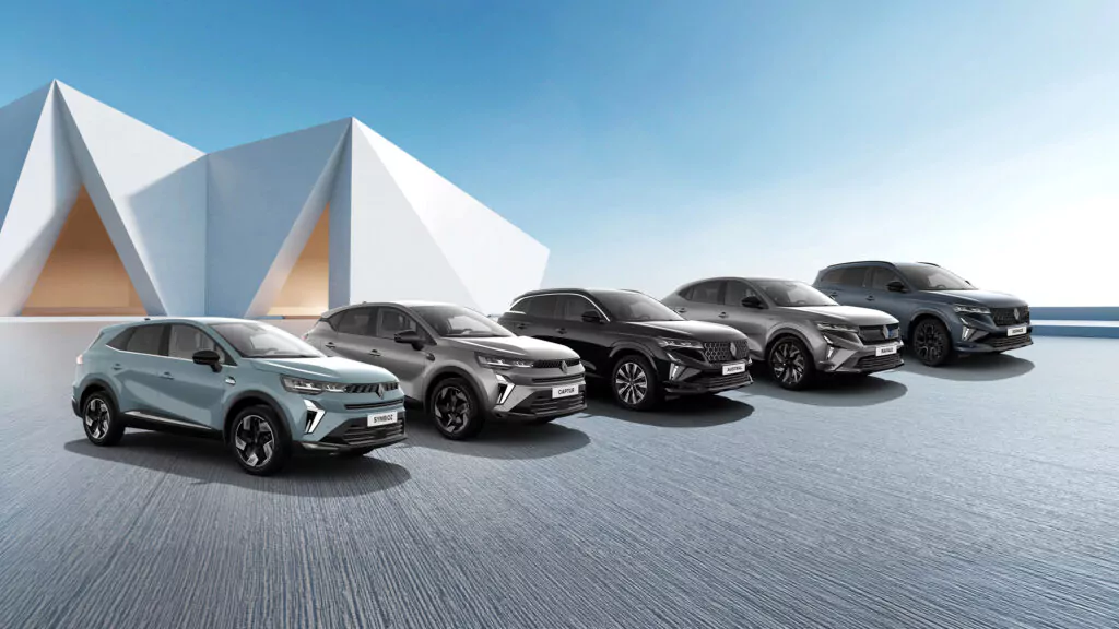 Fünf moderne Renault SUV sind nebeneinander auf einer glatten Fläche geparkt, vor einem modernen weißen, geometrischen Gebäude unter einem klaren blauen Himmel.