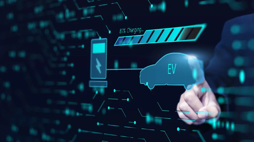 Eine Hand zeigt auf ein digitales Display, auf dem ein Symbol für ein Elektrofahrzeug, ein Batterieladesymbol bei 81 % sowie Grafiken in Form von Schaltkreisen zu sehen sind, die die Technologie von Elektrofahrzeugen und den Ladevorgang symbolisieren.